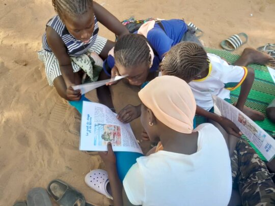 young leader helping children read
